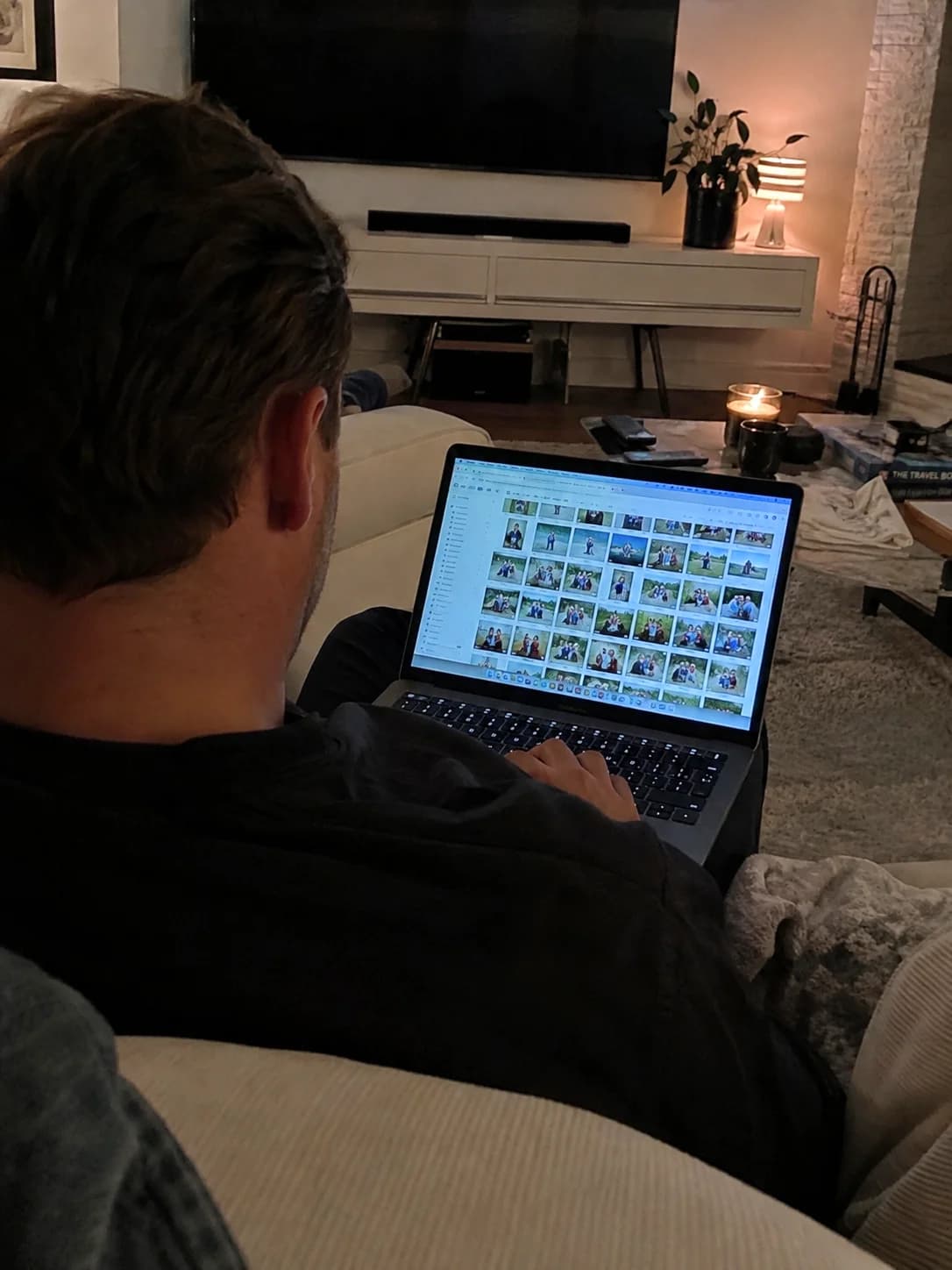A parent looking through a crowded family photo library on a laptop